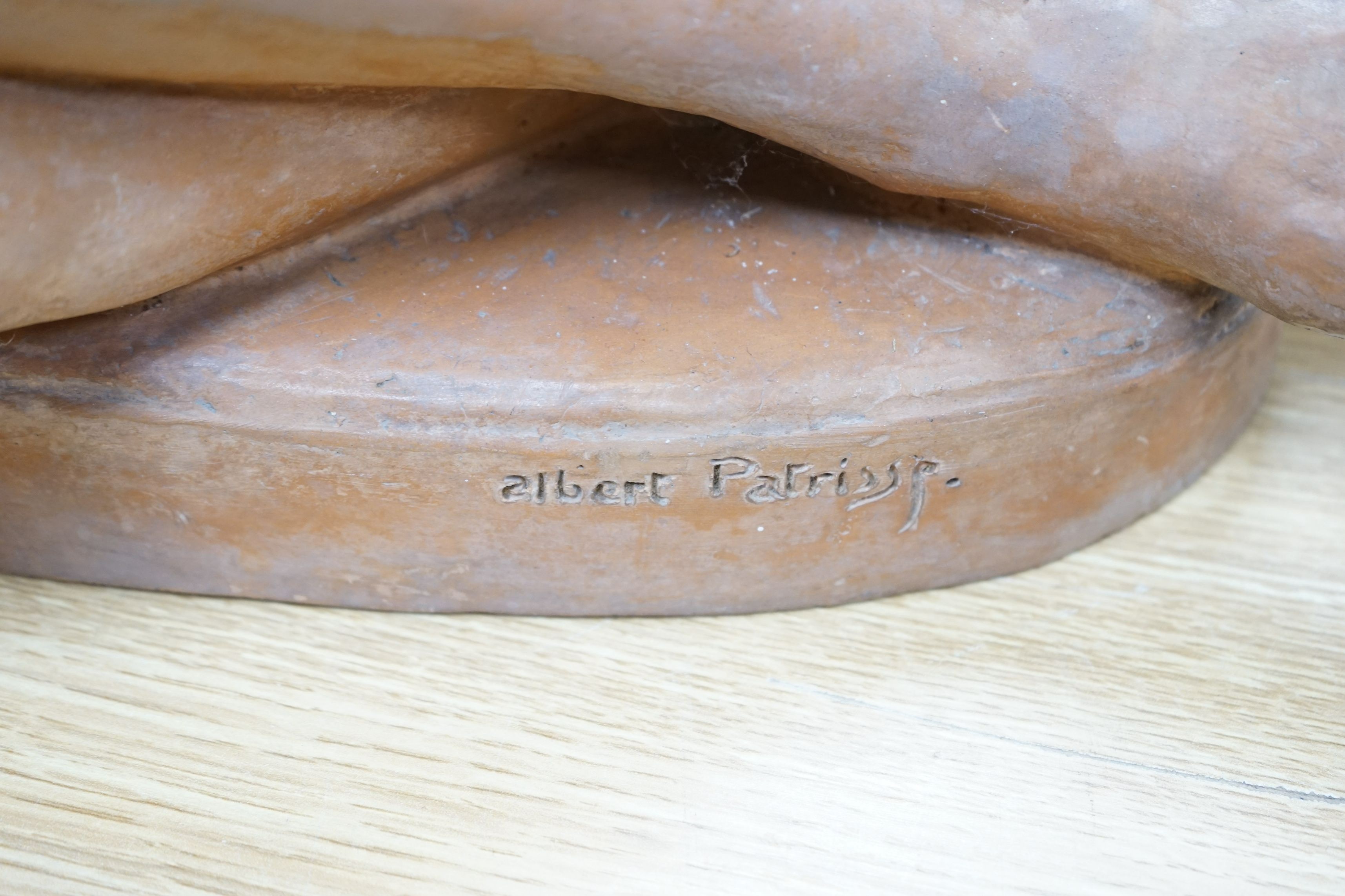 After Albert Patrisse (1892-1964), an Art Deco, signed and stamped, terracotta model of a recumbent nude, 50cms wide x 48cms high